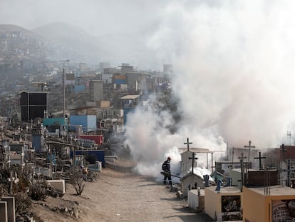 Trabajadores fumigan con vapor el cementerio de Nueva Esperanza, en Lima, por la epidemia de dengue.