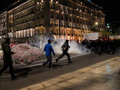 Un grupo de manifestantes trata de escapar del gas lacrimógeno con el que la policía griega intentó disolver una protesta por el accidente de tren, frente al Parlamento, en Atenas, este miércoles.