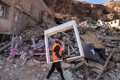 A volunteer helps salvage furniture from homes which were damaged by the earthquake, in the town of Imi N'tala, outside Marrakech, Morocco, Wednesday, Sept. 13, 2023