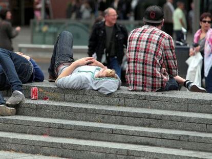 Unos j&oacute;venes descansan en una plaza de Barcelona.