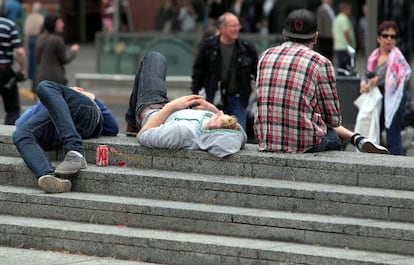 Uns joves descansen en una plaça de Barcelona.