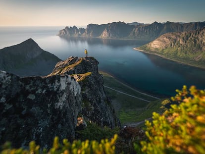 Una mujer contempla el horizonte desde el monte de Husfjell, en la isla de Senja, en Noruega.
