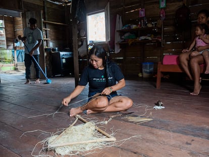 Una mujer del pueblo matís elabora una pulsera con la fibra utucum, una palma amazónica. Su hijo, detrás a la izquierda, estudia secundaria en un colegio de Atalaia.