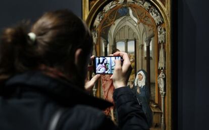 Una mujer fotograf&iacute;a con un m&oacute;vil la &quot;Aparici&oacute;n de Cristo a la Virgen&quot;.