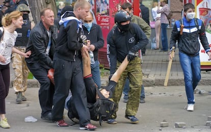 Manifestantes prorrusos cargan con un compa&ntilde;ero herido durante los enfrentamientos con los partidarios del Gobierno de Kiev en la ciudad de Odesa.