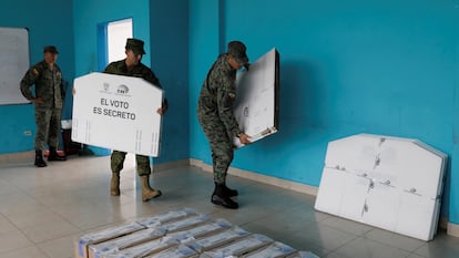 Soldados del ejército ecuatoriano entregan cajas electorales en una mesa electoral.