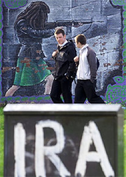 Dos jóvenes pasan ante una pintada de apoyo al IRA, en Belfast (Irlanda del Norte), en una imagen de archivo.