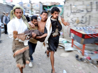 Un herido es trasladado por tres personas tras los enfrentamientos entre manifestantes y tropas del régimen, durante una concentración antigubernamentales en el campus de Saná (Yemen).