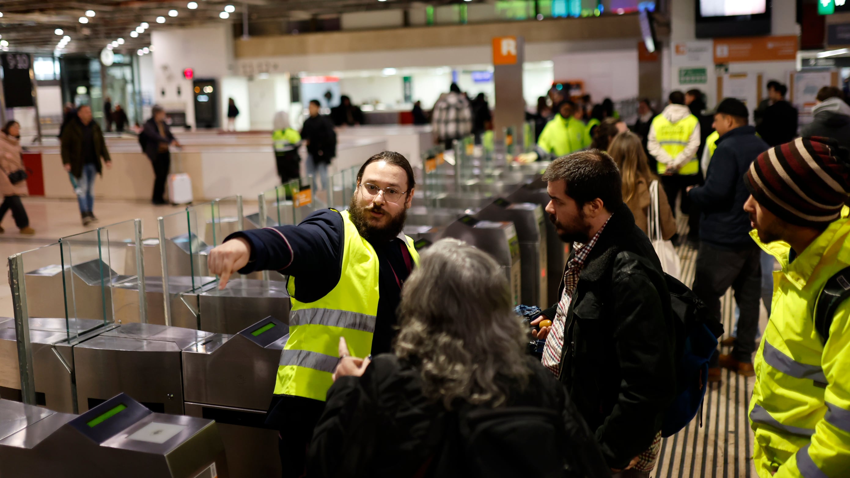 Personal de Rodalies informa del cierre de la circulación a los viajeros en la estación de tren de Sants, el sábado.