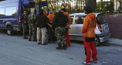 Los agentes griegos conducen esposados a los españoles, el jueves.