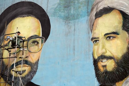 Un pintor retoque un enorme mural con la imagen de los 'mártieres' Mousavi y Shirazi (derecha), en Teherán, Irán.