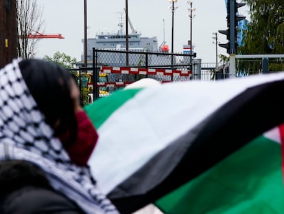 A protester holds a Palestinian flag in front of the MV Cape Orlando as people block the Port of Tacoma entrances in an effort to delay the vessel Monday, Nov. 6, 2023, in Tacoma, Wash. (AP Photo/Lindsey Wasson)