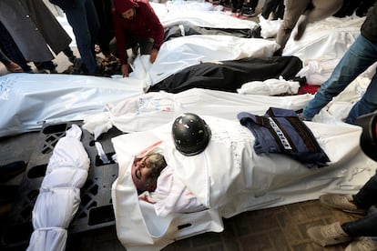 Los cuerpos de ciudadanos palestinos asesinados tras un bombardeo israelí yacen en el suelo. El periodista Adel Zourob, con el rostro descubierto en la imagen, es uno de los fallecidos, en Rafah, al sur de la Franja de Gaza.  
