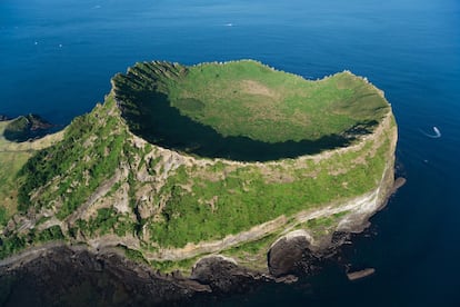 El paisaje volcánico y los túneles de lava de la isla de Jeju, en el suroeste de Corea del Sur, ha hecho triplete en la Unesco: patrimonio mundial, geoparque global y reserva de la biosfera. Abarca tres áreas diferenciadas que suman casi 19.000 hectáreas, algo más de una décima parte de la superficie de la isla: el Geomunoreum, uno de los sistemas de grutas formadas por túneles de lava más bellas del mundo, donde las oscuras paredes de lava contrastan con multicolores techos y suelos carbonatados; el cono de tuf de Seongsan Ilchulbong (pico del Amanecer, en la foto), una espectacular fortaleza que surge de las aguas del océano, y el monte Hallasan, la cumbre más alta del país, con cascadas, formaciones rocosas y un lago en su cráter.