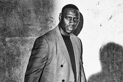 Omar Sy, protagonista de la serie 'Lupin', lleva chaqueta Berluti, camiseta Ami Paris y pantalones Prada. Y, cosa rara en él, no sonríe.