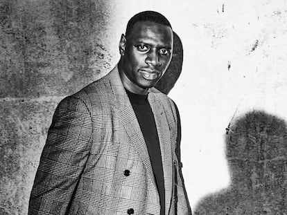 Omar Sy, protagonista de la serie 'Lupin', lleva chaqueta Berluti, camiseta Ami Paris y pantalones Prada. Y, cosa rara en él, no sonríe.