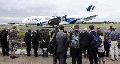 Asistentes a la feria observan un A-380 de Malaysian Airlines durante la exhibición aérea