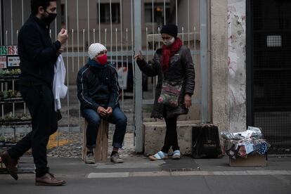 Pessoas protegidas com máscaras transitam em uma rua de São Paulo.