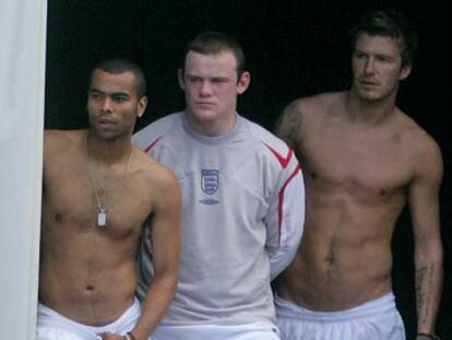 Cole, Rooney y Beckham observan el entrenamiento de ayer de sus compañeros.