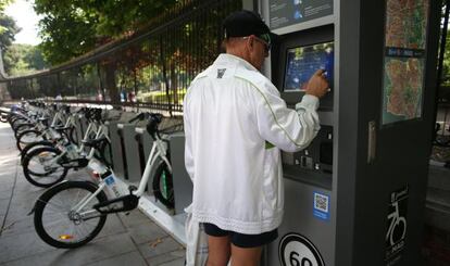 A tourist uses a BiciMad stand by the Retiro Park.
