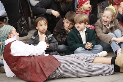 Un grupo de niños asiste a una obra de teatro en la calle de Fuencarral.