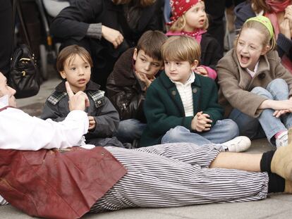 Un grupo de niños asiste a una obra de teatro en la calle de Fuencarral.