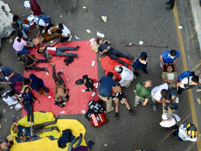 SENSITIVE MATERIAL. THIS IMAGE MAY OFFEND OR DISTURB    Paramedics help people injured at the site of a trailer accident that left at least 49 people dead, most of them migrants from Central America, in Tuxtla Gutierrez, in Chiapas state, Mexico December 9, 2021. REUTERS/Jacob Garcia      TPX IMAGES OF THE DAY