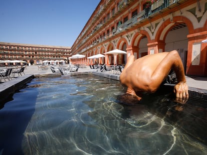 Un hombre mete la cabeza en la fuente de la plaza de la corredera de Córdoba el 3 de agosto, en plena tercera ola de calor de este verano.