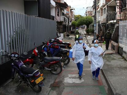 Dos trabajadores de la salud caminan con la vacuna del laboratorio chino Sinovac, en un barrio de Cali, Colombia, el 18 de marzo pasado.