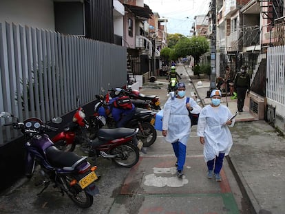 Dos trabajadores de la salud caminan con la vacuna del laboratorio chino Sinovac, en un barrio de Cali, Colombia, el 18 de marzo pasado.