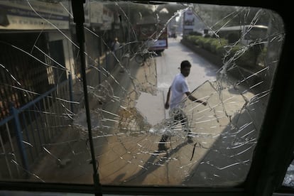 Un hombre mira la ventanilla rota de un autobús durante una protesta de los grupos 'dalits' en Bombay (India).