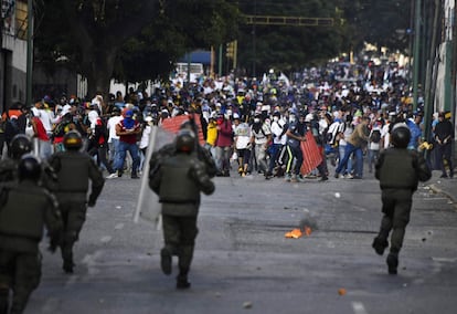 Miembros de la GNB corren hacia una concentración de manifestantes en Caracas, tras una jornada de protestas en la capital en contra de Nicolás Maduro y en apoyo a Juan Guaidó, presidente interino de Venezuela.