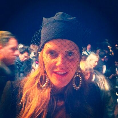 Anna dello Russo con maxipendientes y tocado de red en el desfile de Michael Kors.