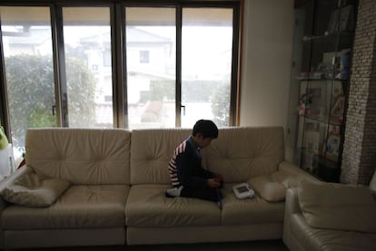 "Trato de evitar salir y abrir la ventana," dice Ayumi Kaneta, de 34 años, madre de tres hijos. "Yo compro los alimentos en zonas alejadas de Fukushima. Esta es nuestra vida normal". En la imagen, Masyoshi Kaneta de siete años juega con su Nintendo WiiU en la sala de estar de su casa en Koriyama.