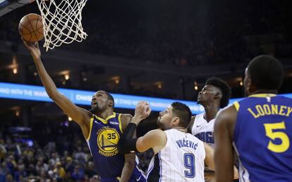 Kevin Durant anota ante Vucevic.