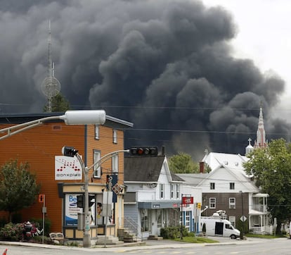 Una nube de humo se eleva sobre las calles de Lac Megantic después de la explosión en un tren cargado de petroleo.)