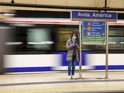 Pasajera del metro consultando su teléfono en a estación de Avenida de América.