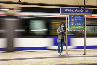 Pasajera del metro consultando su teléfono en a estación de Avenida de América.