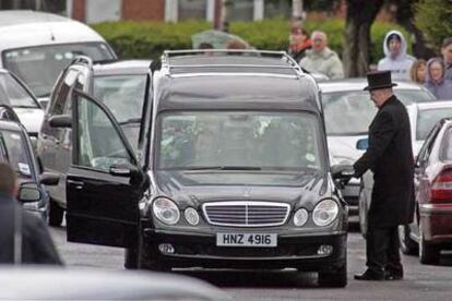 Un furgón traslada el féretro de Denis Donaldson ayer en el cementerio de Belfast.