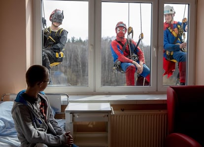 Tres hombres vestidos de súper héroes limpian las ventanas del Centro de salud infantil Juan Pablo II de la Alta Silesia, en Katowice (Polonia).