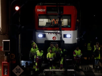 Varios operarios, junto al tren de Cercanías que descarriló el martes 5 en la entrada de la estación de Atocha.