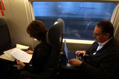 Viajeros trabajando con el ordenador en el primer viaje del AVE línea Barcelona-Madrid-Barcelona.