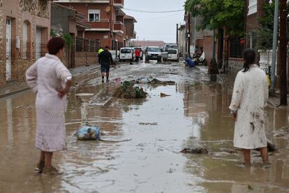 Varias personas tratan de limpiar el lodo tras la lluvia caída en la localidad toledana de Cobeja.