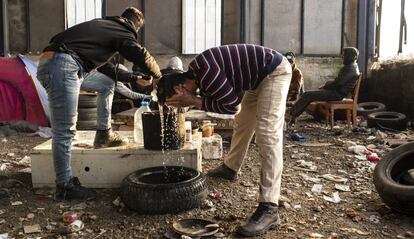 Migrantes argelinos se lavan con una garrafa de agua en una nave industrial el pasado enero, en Velika Kladuša, una ciudad cercana al campo de Bihac, las dos en Bosnia y Herzegovina.