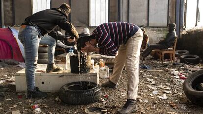 Migrantes argelinos se lavan con una garrafa de agua en una nave industrial el pasado enero, en Velika Kladuša, una ciudad cercana al campo de Bihac, las dos en Bosnia y Herzegovina.
