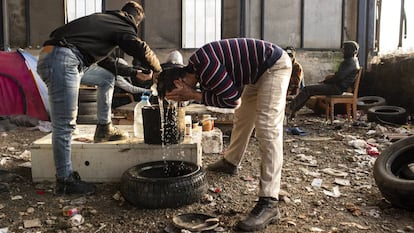 Migrantes argelinos se lavan con una garrafa de agua en una nave industrial el pasado enero, en Velika Kladuša, una ciudad cercana al campo de Bihac, las dos en Bosnia y Herzegovina.