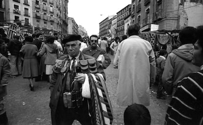 Un vendedor ambulante muestra su catálogo de monederos y corbatas.