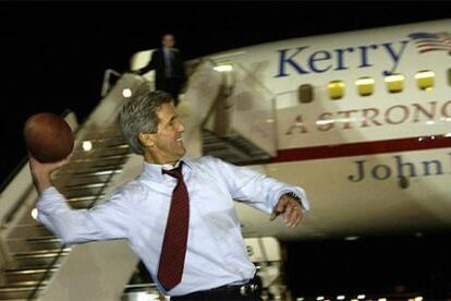 El candidato demócrata John Kerry lanza un balón de fútbol americano en la pista del aeropuerto de Phoenix tras su debate con Bush.