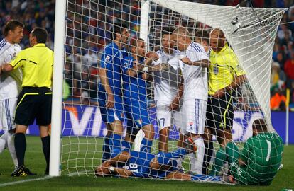 El arbitro del encuentro intenta poner paz entre los jugadores tras un lance entre el portero eslovaco Jan Mucha y el jugador italiano Fabio Quaglirella, ambos en el suelo, tras el primer gol de Italia.