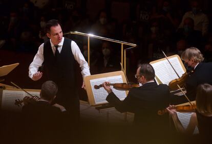 Teodor Currentis, dirigiendo a su orquesta musicAeterna entremezclado con sus músicos.